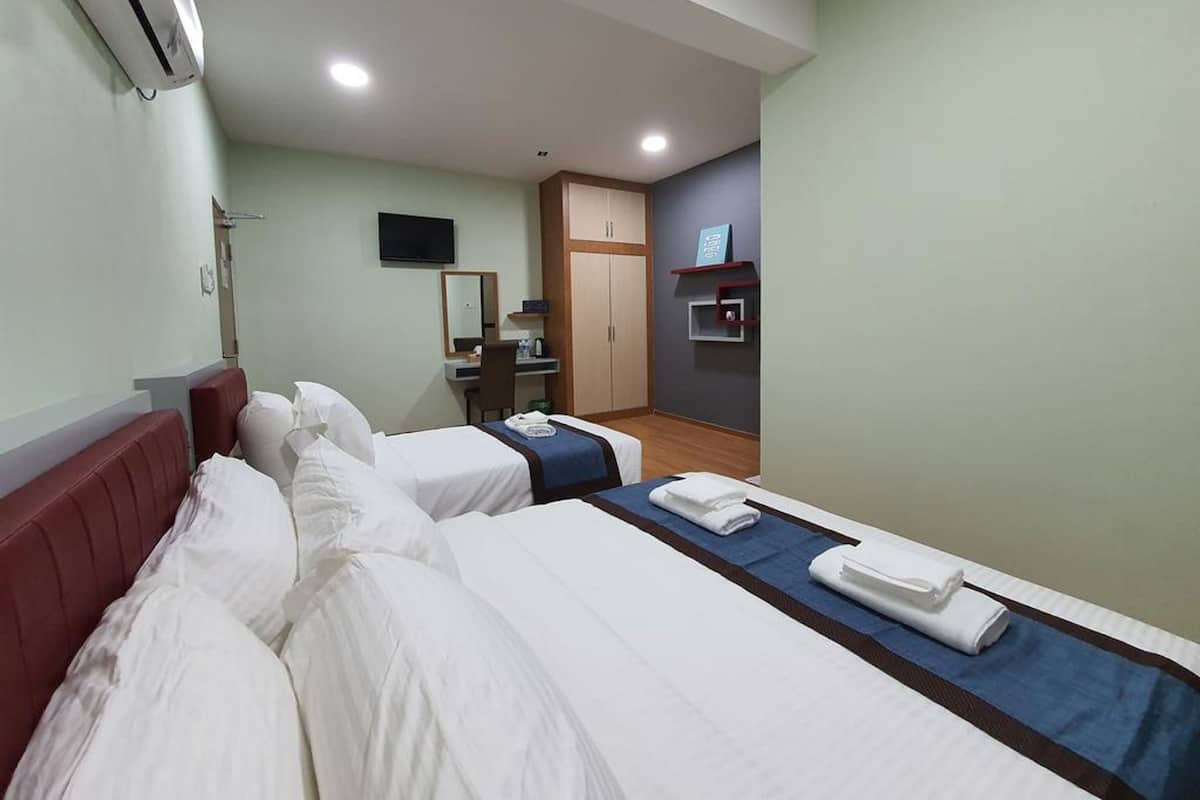 Une chambre d’hôtel avec deux lits, un bureau, une chaise, une télévision et une armoire.