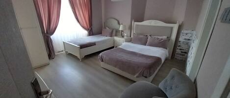A bedroom with a bed, a chair, a nightstand, and an air conditioning unit.