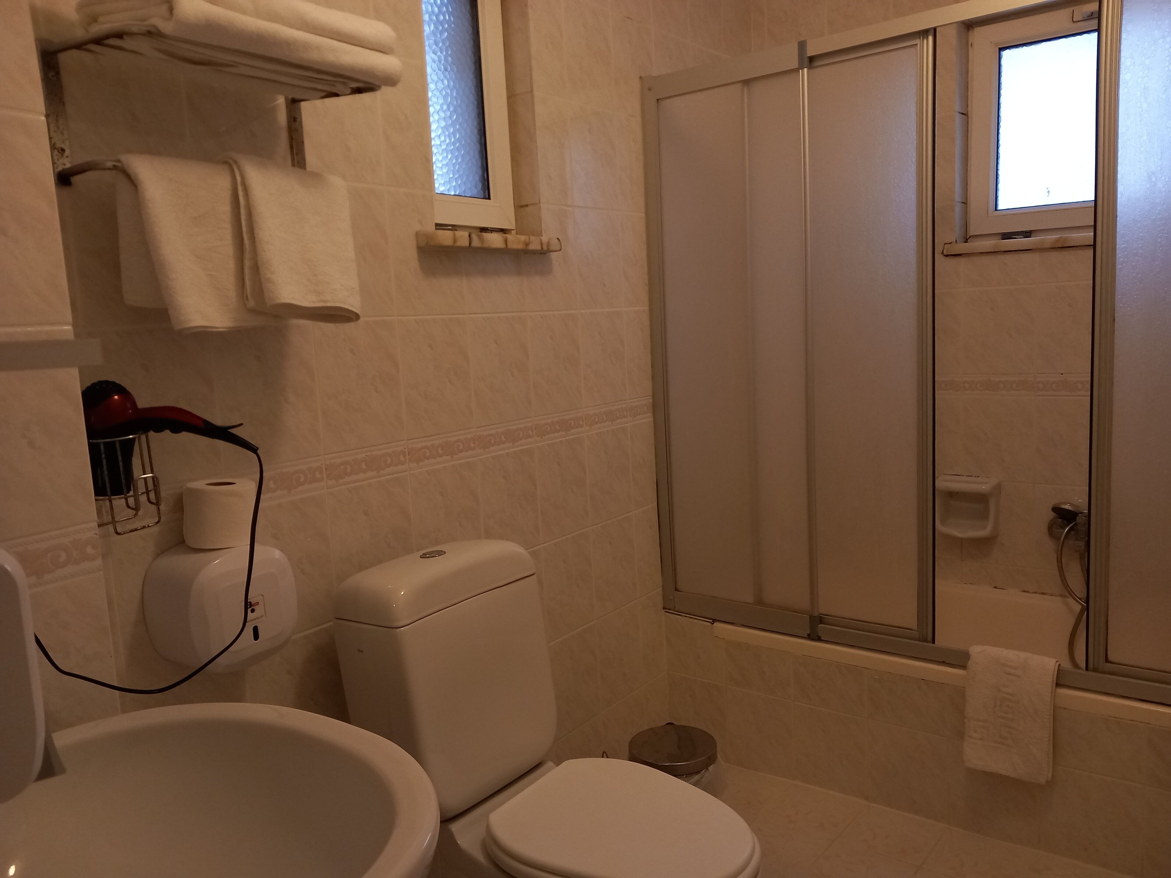 A bathroom with a toilet, bidet, and a glass-enclosed shower.