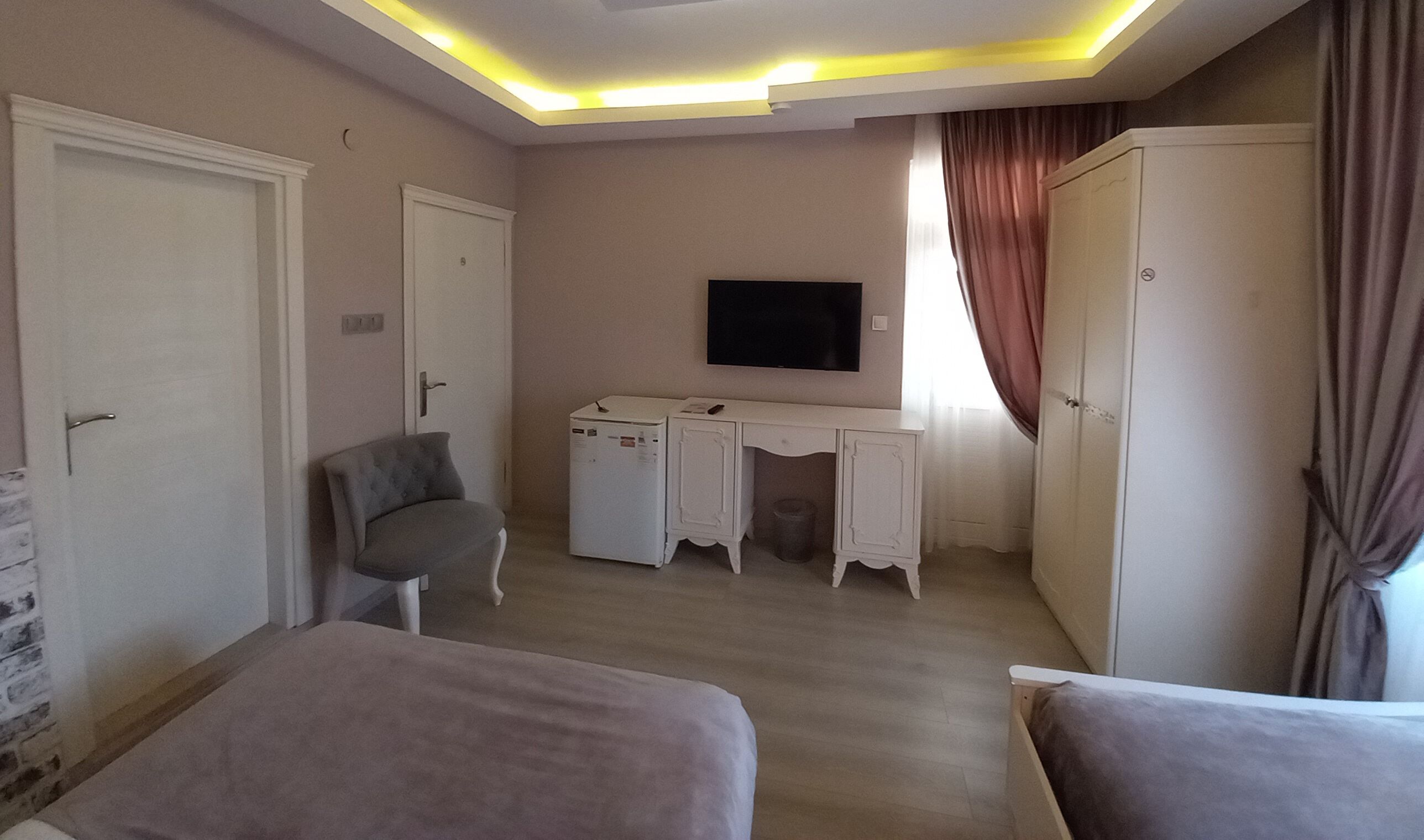Un dormitorio con cama, escritorio, televisor y armario.