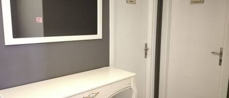 A room with a white vanity, a mirror, and two doors labeled "Orkide" and "Hanumeli".