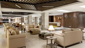 A spacious lobby with multiple seating areas, a reception desk, and a modern ceiling design. - Aston Gresik Hotel & Conference Center (Gresik)