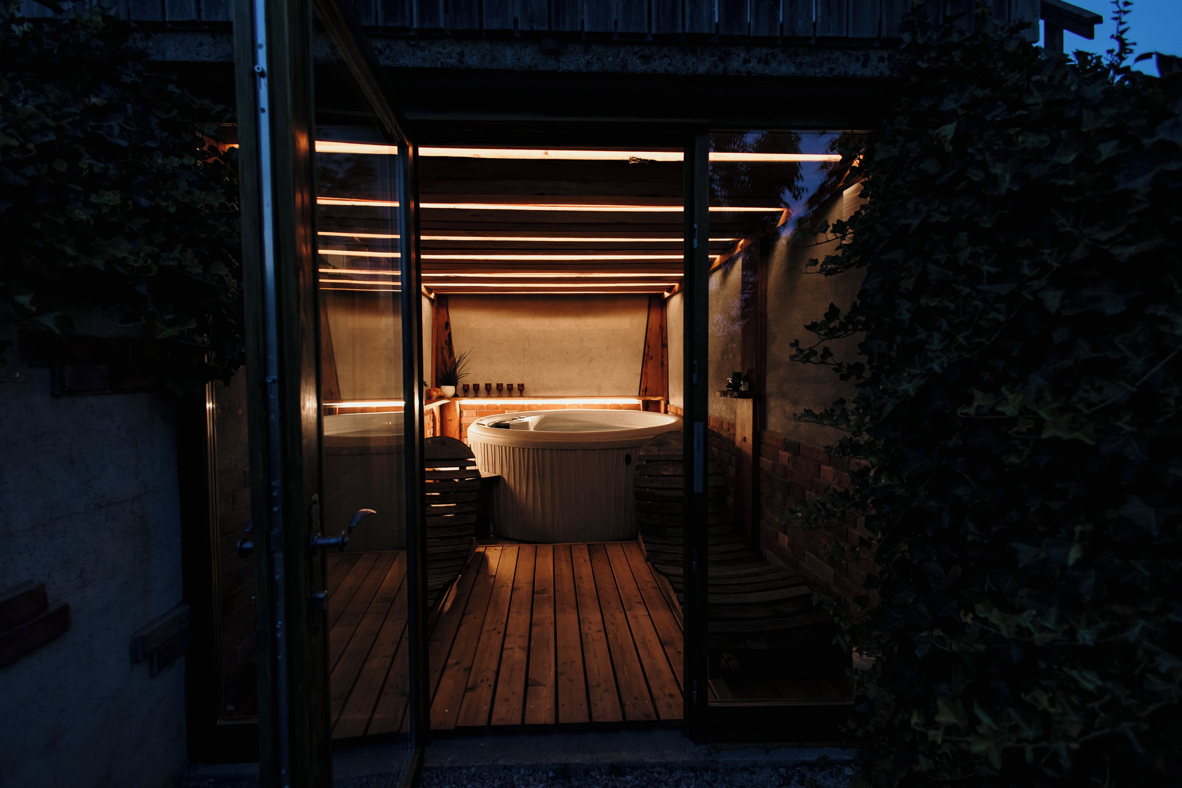 A spa area with a hot tub and a wooden deck.