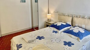 A bedroom with a bed, a nightstand, a lamp, and a wardrobe. - Rental small 3 Pieces Historic Center (Menton)