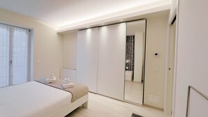Un dormitorio moderno con una cama, un armario y un espejo.