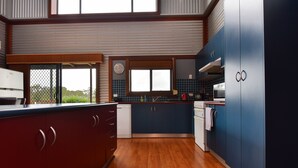 A modern kitchen with wooden cabinets, a built-in oven, and a large window.