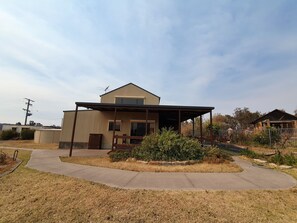 A single-story house with a covered porch and a small garden area.