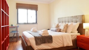Une chambre à coucher avec un lit, une table de chevet et une fenêtre avec des stores.