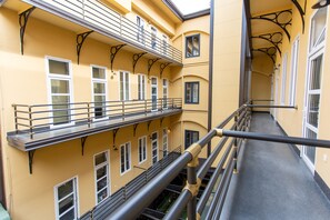 Ein mehrstöckiges Gebäude mit Balkonen, Geländern und Fenstern.