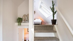 A staircase with a ceiling window, a bed, and a cactus plant. - Sprielderbosch 17 Luxury holiday home Veluwe, located in the woods (Putten)