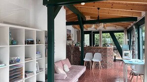 A cozy living area with a sofa, bookshelves, and a brick fireplace.