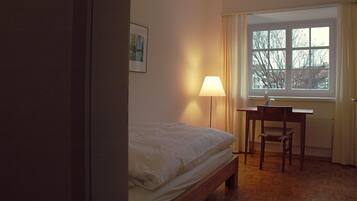 Une chambre à coucher avec un lit, un bureau et une fenêtre.