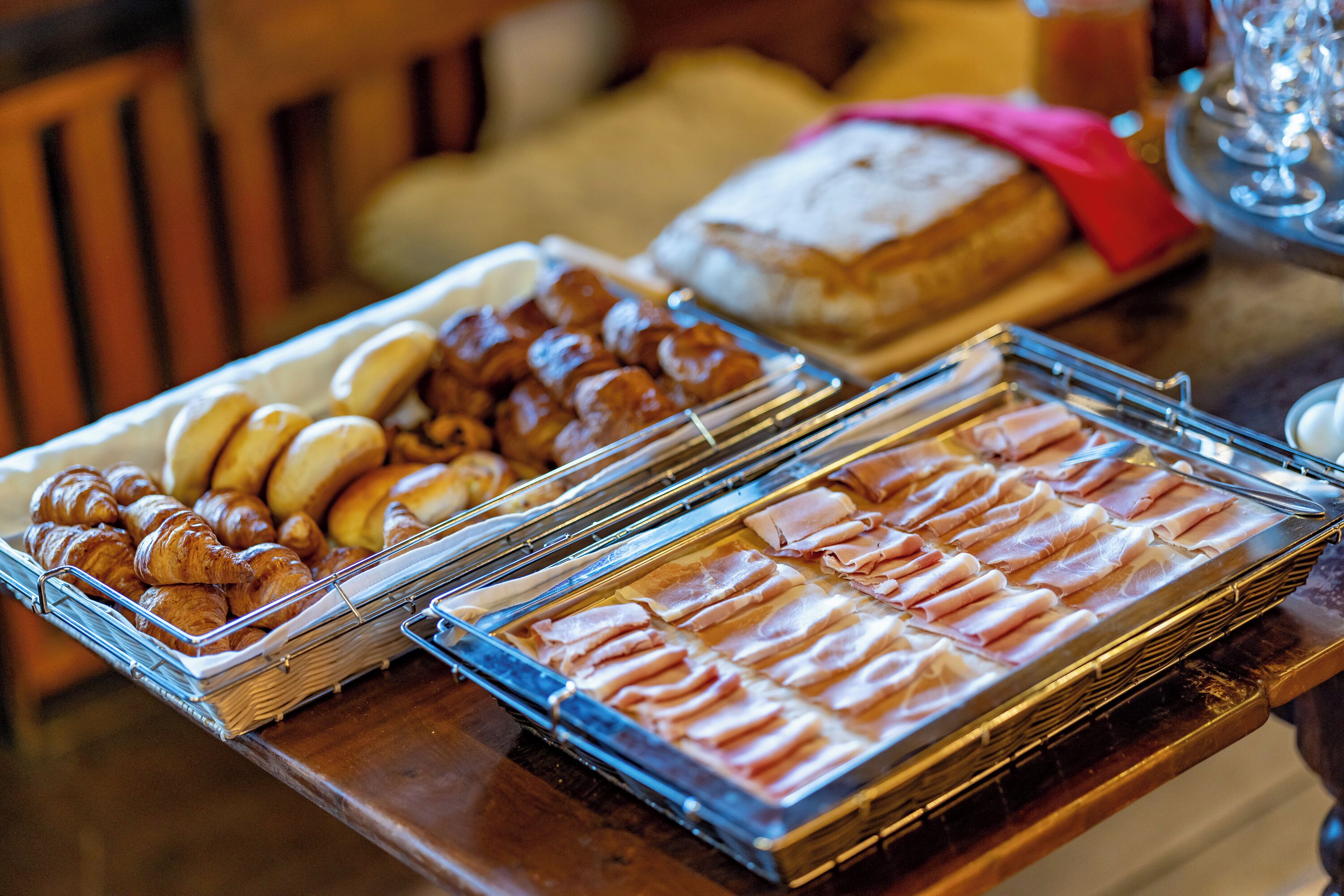 Una mesa de buffet con diversos alimentos, incluyendo pasteles y carnes.