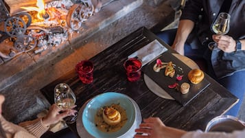A table with a candlelit ambiance, a bowl of food, and red glasses.