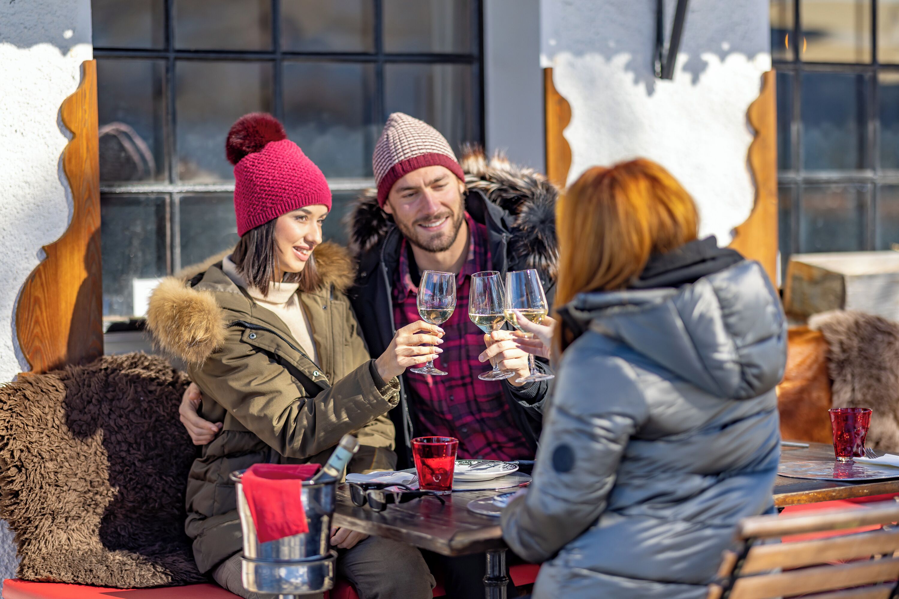 Un grupo de personas sentadas en una mesa al aire libre, con bebidas, posiblemente en un café o restaurante.