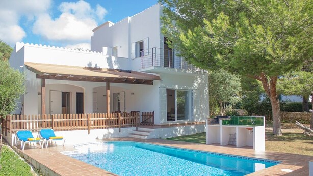 Une maison moderne à deux étages, dotée d’une piscine, d’un patio couvert et d’une clôture en bois.