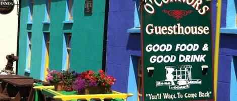 A colorful building with a sign advertising 'O'Connor's Guesthouse' offering 'good food & good drink'.