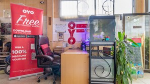 Ein Empfangsbereich mit einem roten Werbebanner, einem Empfangstresen, einem Aquarium und einer Topfpflanze.