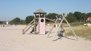 A beach play area with a climbing structure and swings. - 3 room apartment 80sqm - Apartments Eggert (Neustadt in Holstein)