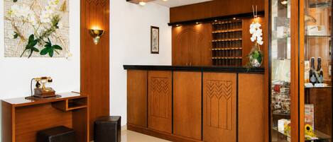 A modern kitchen with wooden cabinets, a black countertop, and a glass display case.