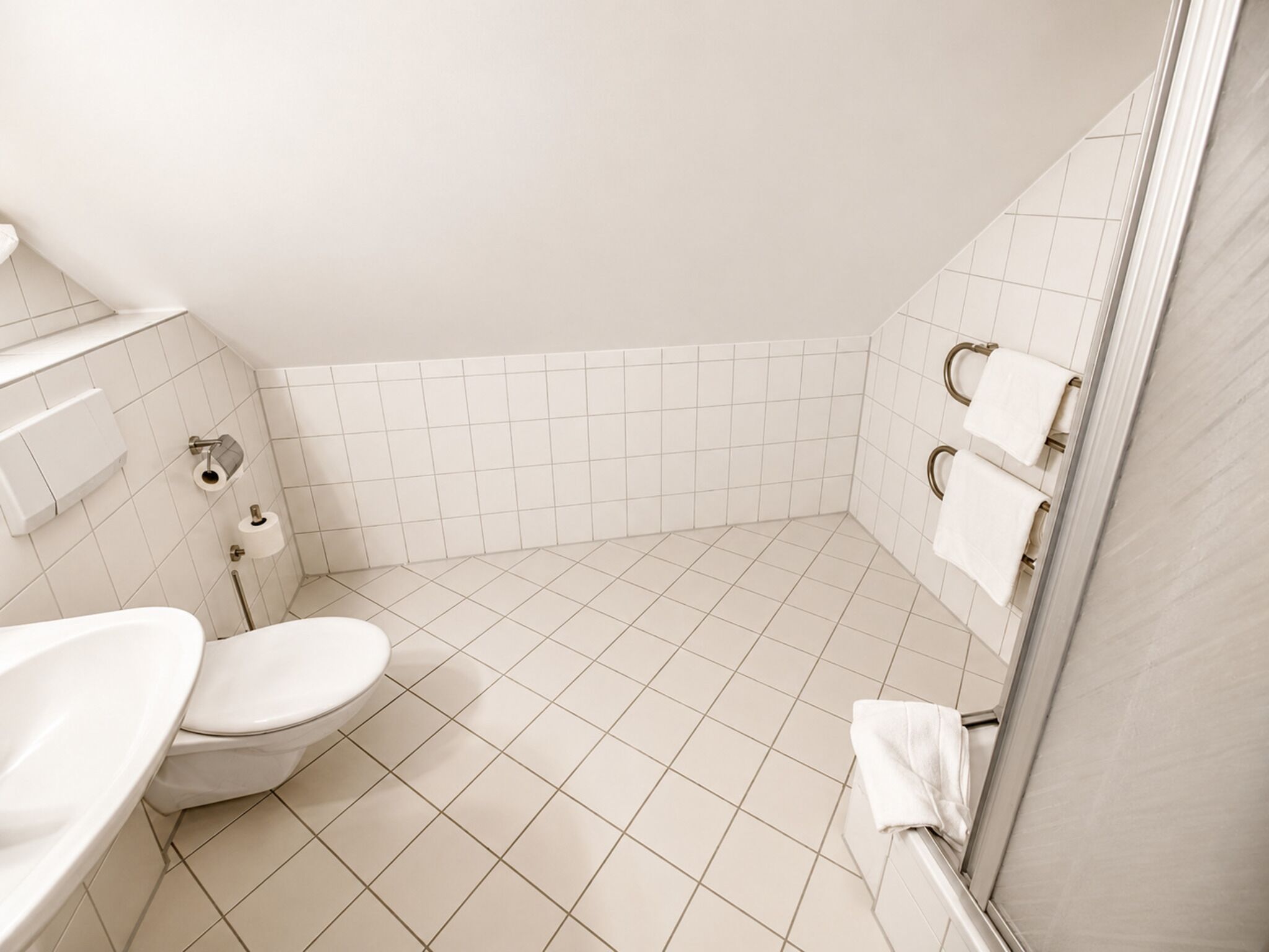A bathroom with a toilet, sink, and towel rack.