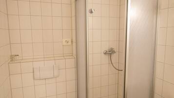 Un bagno con il water, uno stendimento doccia e un lavandino.
