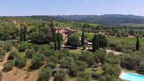 A villa surrounded by lush greenery and a clear blue sky.