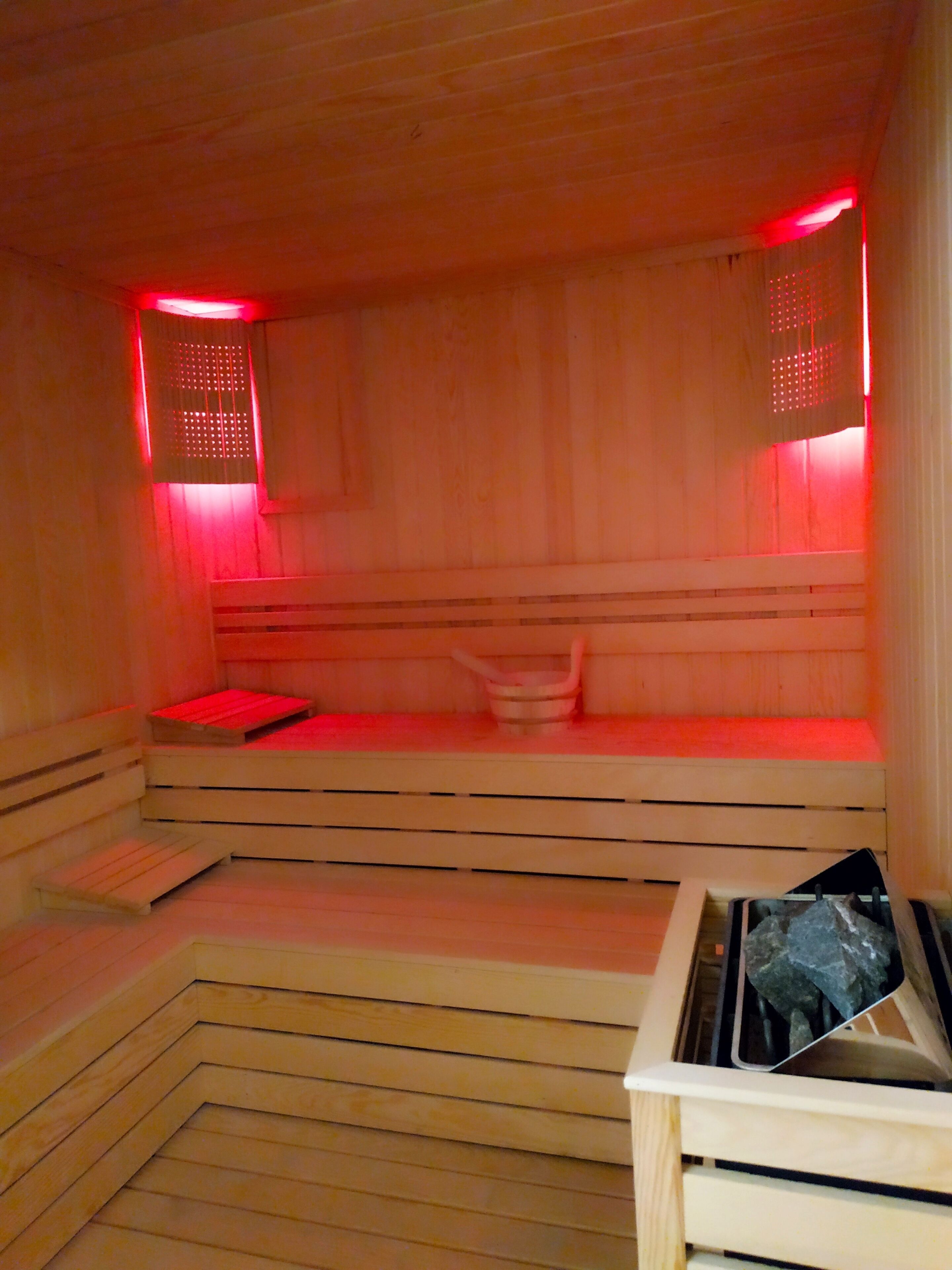 A sauna with wooden benches and a bench with a towel.