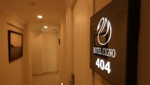 Un pasillo con un cartel que indica el Hotel Cigno, habitación 404.