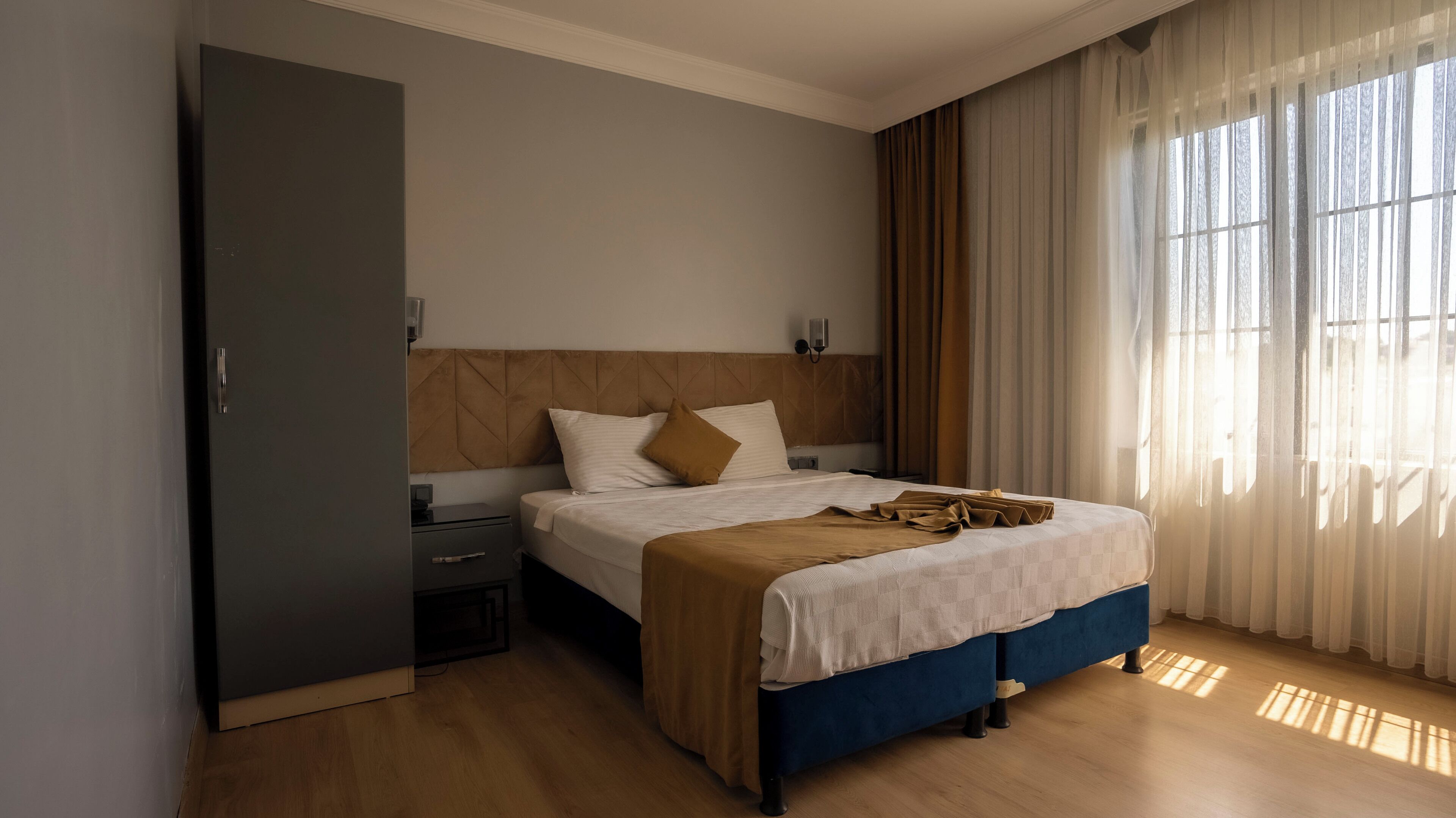 A bedroom with a bed, nightstand, and a wardrobe.