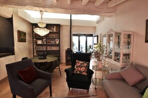 A cozy living room with a fireplace, a bookshelf, and a dining area.