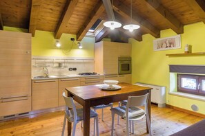 A kitchen with wooden cabinets, a dining table, and chairs.
