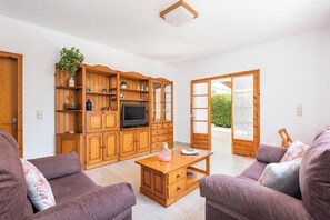A living room with a wooden TV stand, a sofa, and a coffee table.