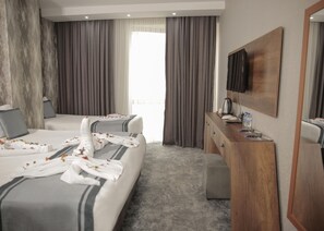 A hotel room with two beds, a wooden dresser, a flat-screen TV, and a large window with curtains. - Istanbul Airport Express Hotel (Arnavutköy)