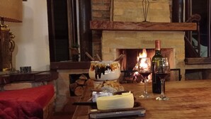 A cozy room with a fireplace, a wooden table with food and drinks, and a television.