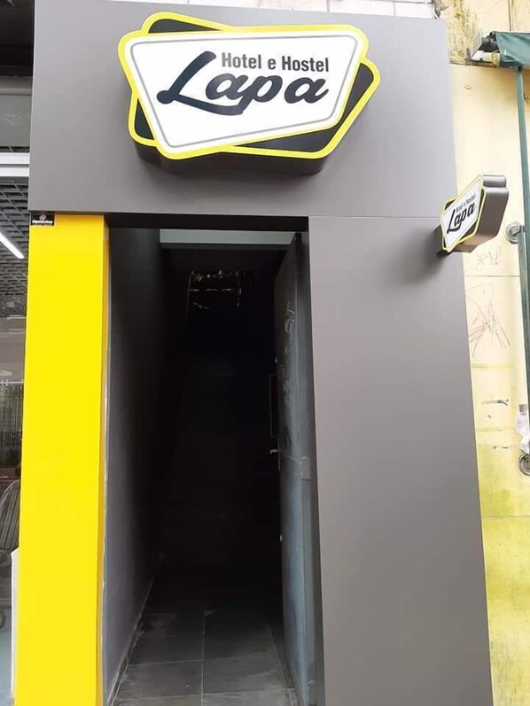 A building entrance with a sign reading "Hotel e Hostel Lapa".