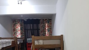 Un dormitorio con literas, un armario rojo y un televisor.