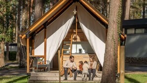 Une cabane en bois avec un toit à deux versants et une véranda couverte.