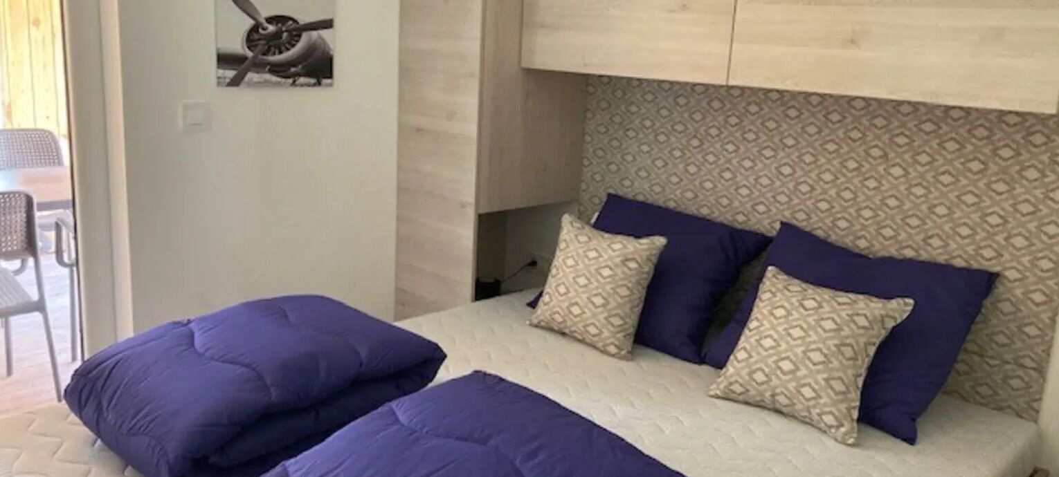 A bedroom with a bed, pillows, and a headboard.