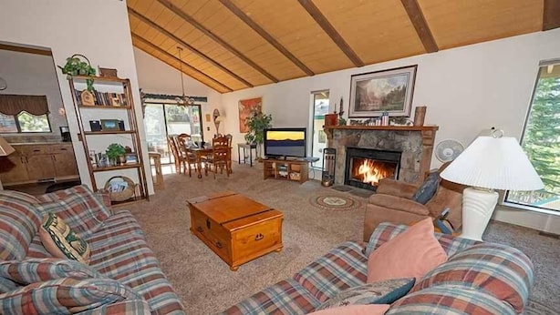 A cozy living room with a fireplace, a television, and a bookshelf. - 3407 Pine Hill 2 Bedroom Home by RedAwning (South Lake Tahoe)