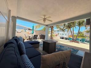 An outdoor patio with a sofa, chairs, a table, and a ceiling fan. - R & K’s Marathon Paradise 2/2 Duplex w/35` Dock & Cabana Club Included (Marathon)