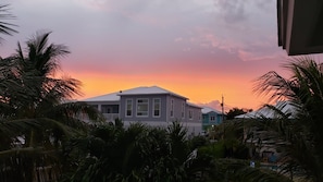 A residential building with a flat roof, surrounded by palm trees, during sunset. - R & K’s Marathon Paradise 2/2 Duplex w/35` Dock & Cabana Club Included (Marathon)