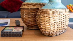 Deux paniers tressés sont posés sur une table en bois, et une œuvre d’art encadrée se trouve à l’arrière-plan.