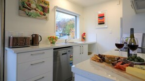 Eine moderne Küche mit Geschirrspüler, Toaster, Spüle und Fenster.