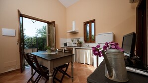 Una cucina con tavolo da pranzo, sedie, piano cottura, lavello e una finestra.
