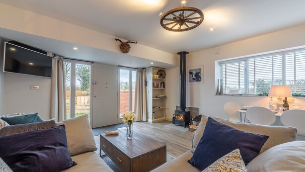 A cozy living room with a sofa, coffee table, and a fireplace. - Wheelwrights, Sustead, Norfolk (Sustead)