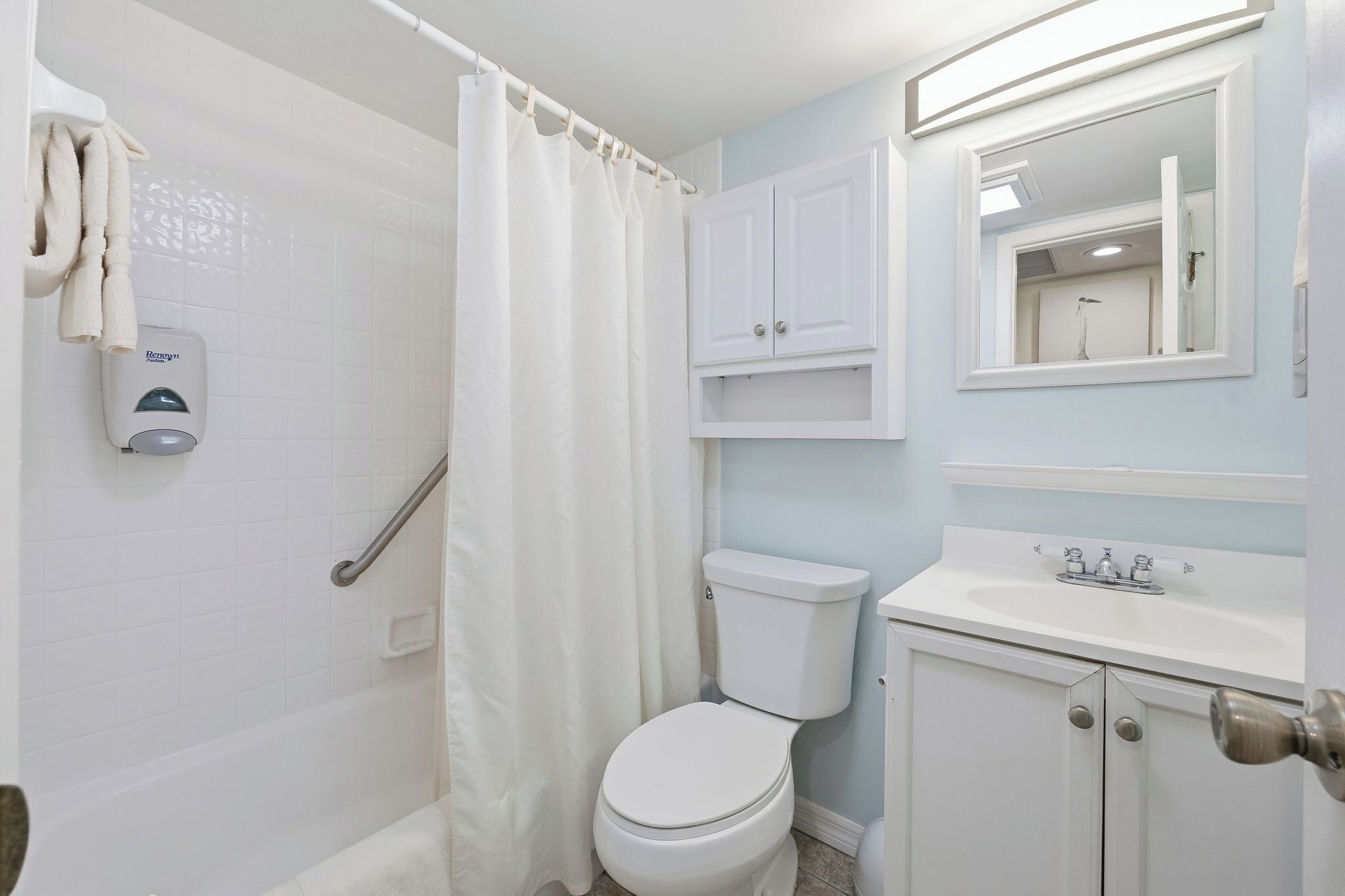 A bathroom with a shower, toilet, and sink.