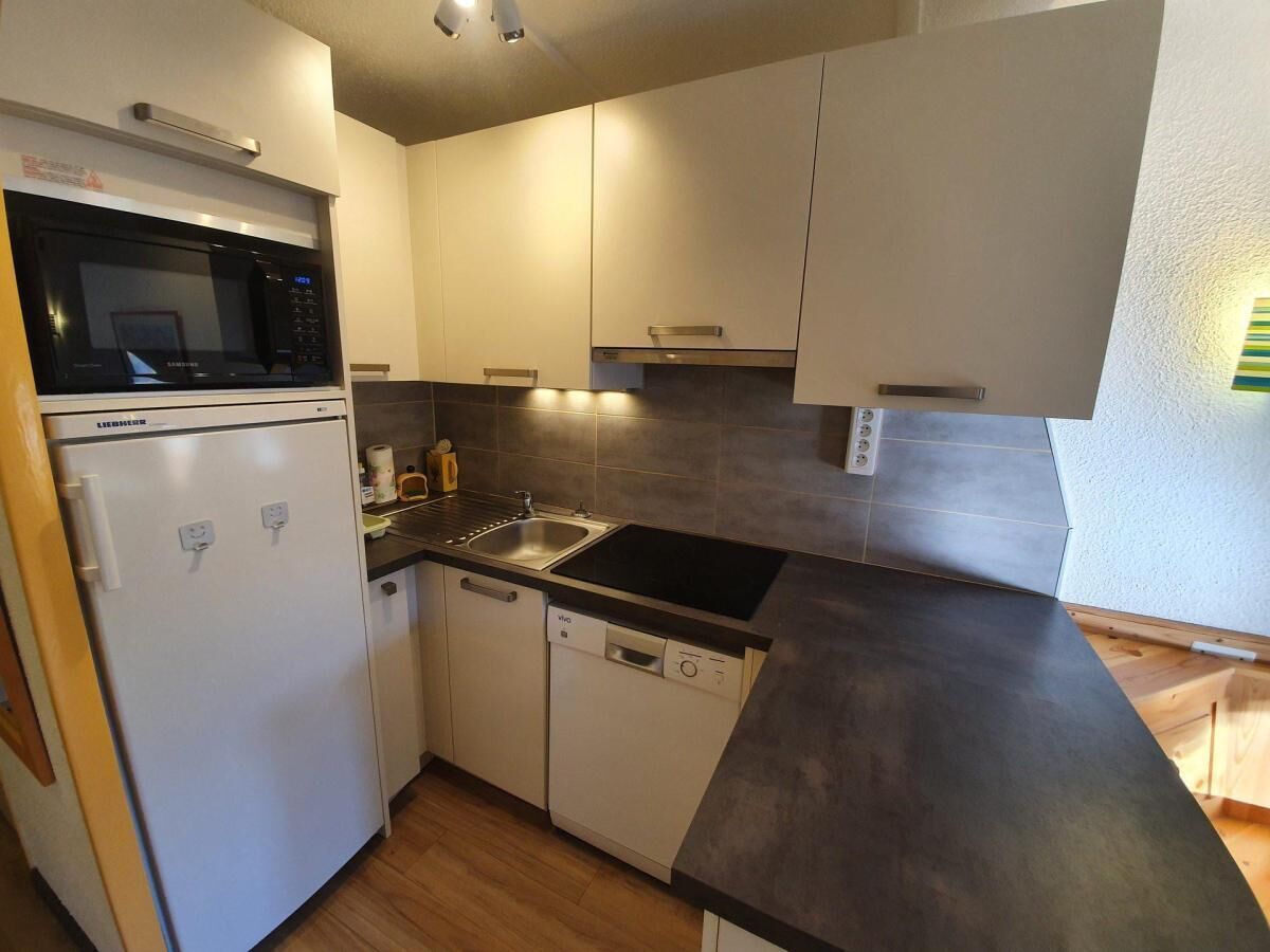 A compact kitchen with a built-in microwave, a dishwasher, and a sink.