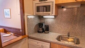 A compact kitchen with a built-in oven, a coffee maker, and a dishwasher. - 100m from ski slopes, 10th floor, view mountain, balcony, tv, ski locker, 31m², Les Orres (Les Orres)