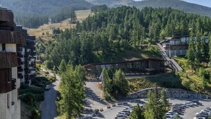 A mountain lodge with a parking area, surrounded by forested hills. - 100m from ski slopes, 10th floor, view mountain, balcony, tv, ski locker, 31m², Les Orres (Les Orres)